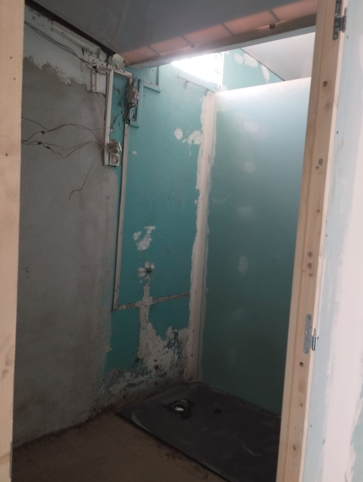 Chantier de salle d’eau : cloisons en placo hydrofuge vert, bandes à joint et receveur de douche posé